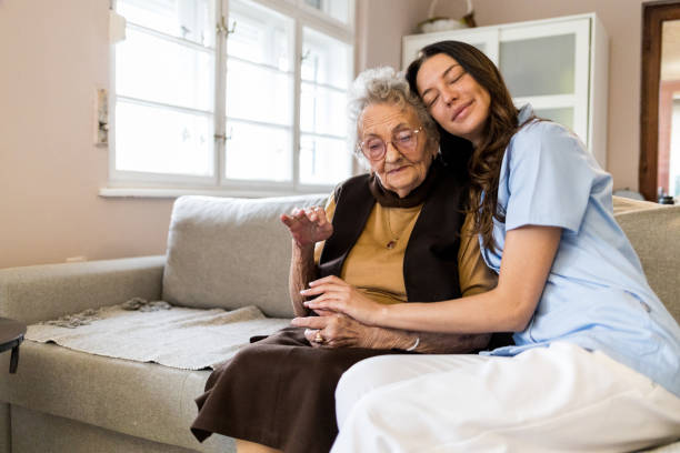 istock Beautiful young nurse hugging 90 year old patient 1396300862