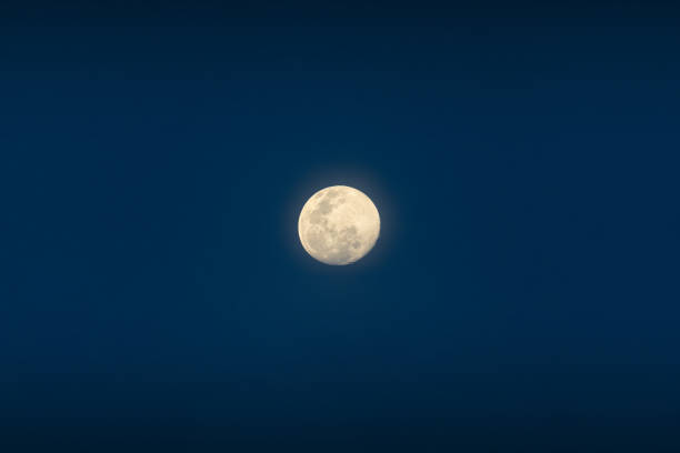 la pleine lune brille sur le ciel bleu au crépuscule - dramatic sky dusk night sustainable resources photos et images de collection