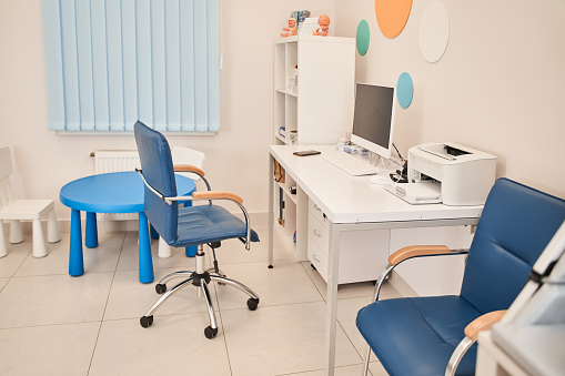 Full length view of the modern interior of pediatrician doctor office. No people at the room. Medicine concept. Stock photo