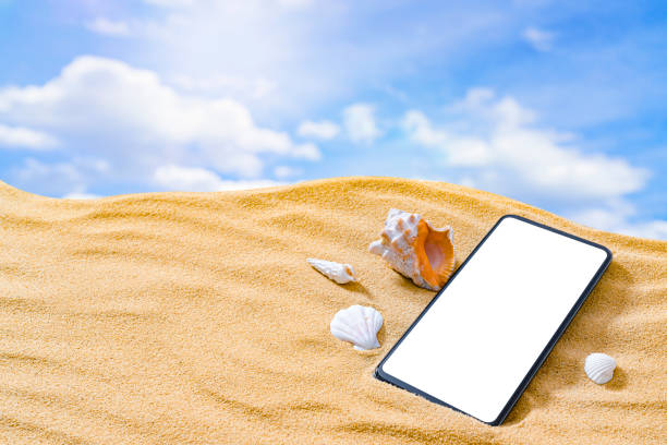 istock Smartphone laying on golden beach sand. Copy space 1396304902