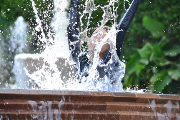 istock A kid playing in the pool splashing water around. 1396305835