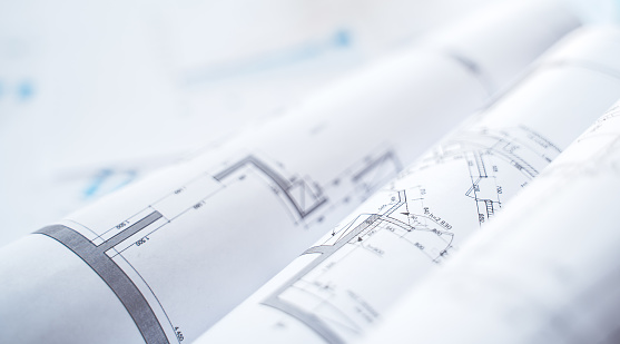 Business project documentation, development, planning and approval. Construction drawings for building, apartment, financial diagrams, investment plan, documents. Making repairs. Blurred background.