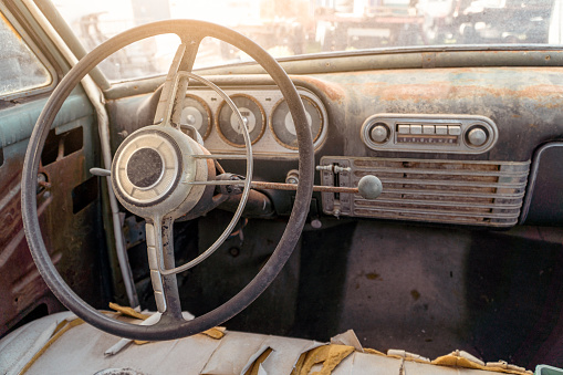 dashboard of an abandoned vintage car. Old speedometer, fuel meters, gauges and radio.