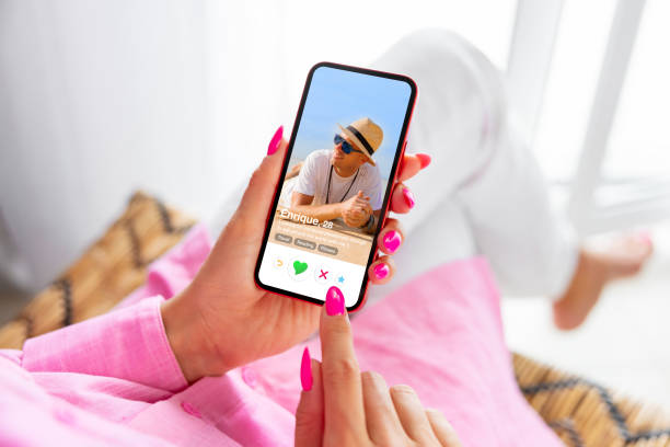 mujer usando la aplicación de citas en línea en el teléfono y viendo el perfil de alguien - internet dating fotografías e imágenes de stock