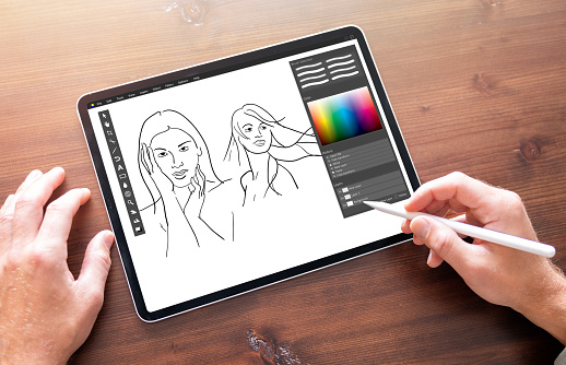 Person drawing sketches on digital tablet