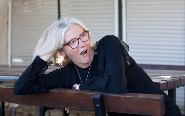 istock Surprised woman outside on bench 1396308679