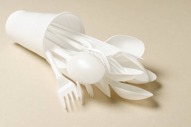 istock Disposable white plastic tableware on a beige background. The concept of nature pollution. Copy space. 1396310173