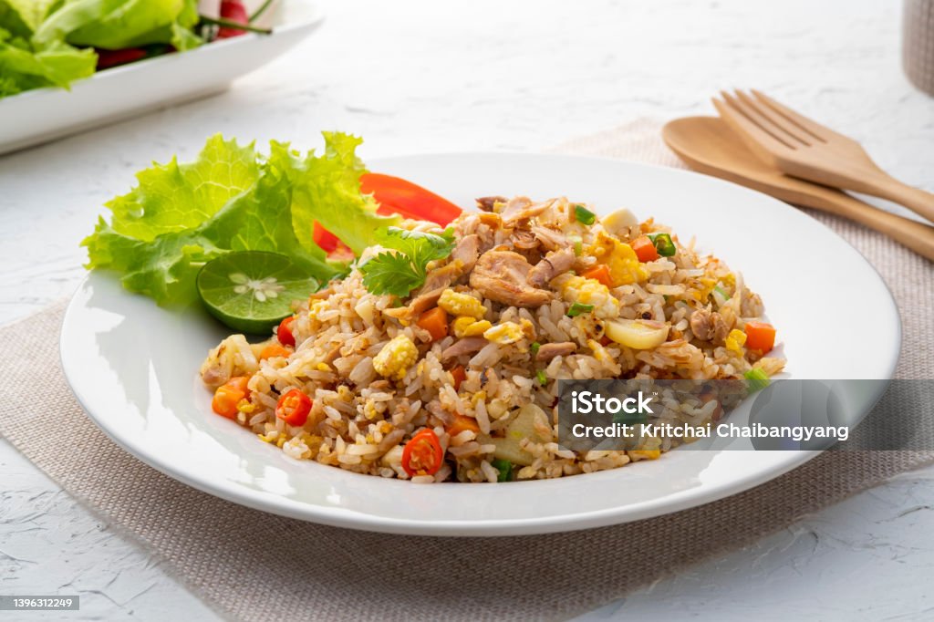 Fried Rice with canned Tuna fish Fried Rice with canned Tuna fish.Quick and Easy Thai style spicy one dish meal on white plate Fried Rice Stock Photo