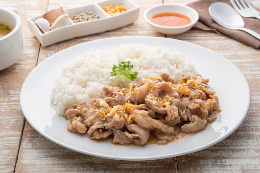 Stir-Fried Pork with Garlic and and pepper with cooked thai jasmine rice in white plate,popular Thai Street food