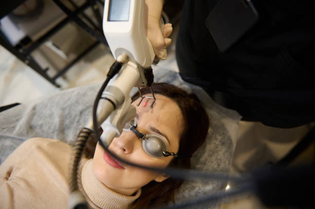 istock Beautician using laser handle on middle aged woman face while making laser skin resurfacing in aesthetic medicine 1396312471