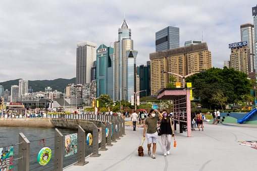 Hong Kong - May 9, 2022 : People at the promenade next to Victoria Harbour in Wan Chai Harbourfront, Hong Kong.