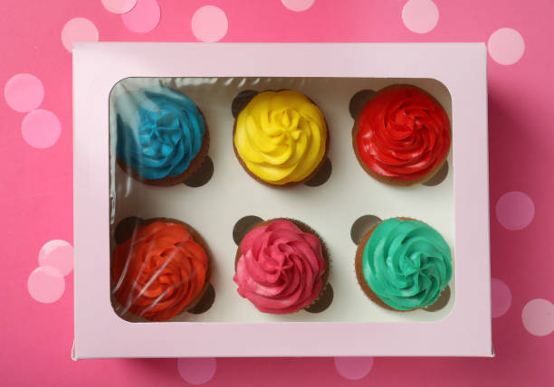 istock Box with different cupcakes and confetti on pink background, flat lay 1396315366