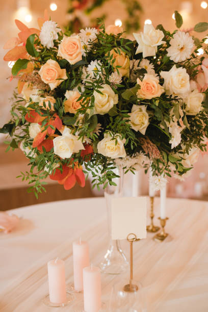 istock Table setting at the wedding reception. Floral compositions with beautiful flowers and greenery, candles, laying and plates on a decorated table. 1396315791