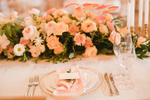 istock Table setting at the wedding reception. Floral compositions with name card on vintage plate on a decorated table. 1396316004