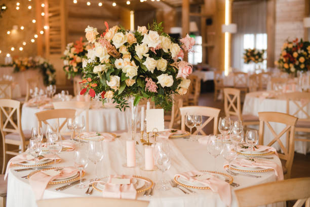 istock Table setting at the wedding reception. Floral compositions with beautiful flowers and greenery, candles, laying and plates on a decorated table. 1396316014