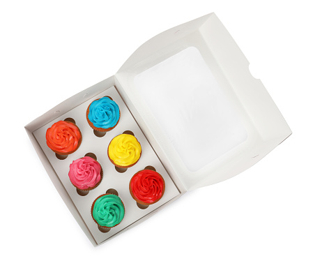Box with different cupcakes on white background, top view