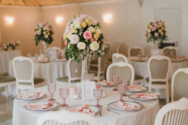 istock Table setting at the wedding reception. Floral compositions with beautiful flowers and greenery, candles, laying and plates on a decorated table. 1396316681