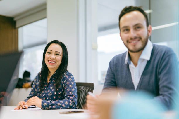 istock Smiling colleagues at company meeting 1396318270