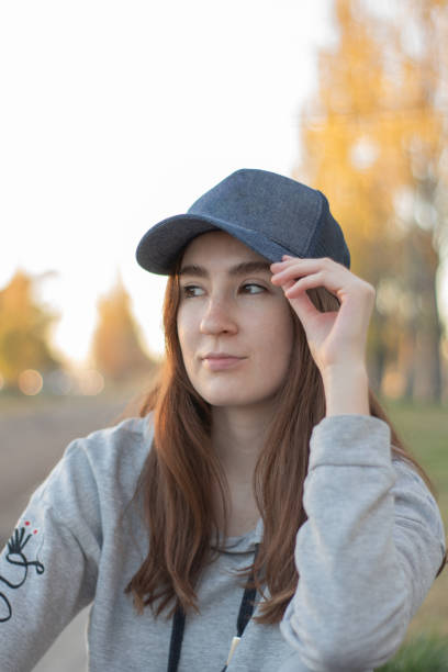 istock Woman wearing a cap in the park at sunset 1396319701