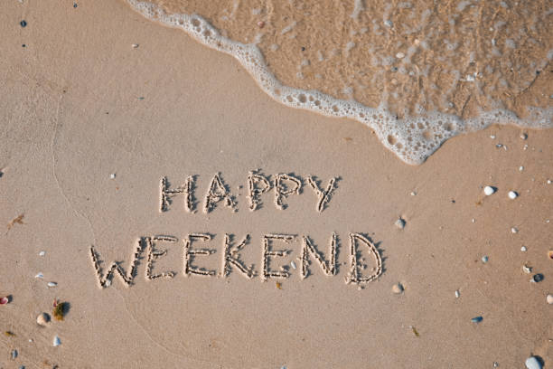 istock Phrase Happy weekend written on sand at beach, top view 1396320963