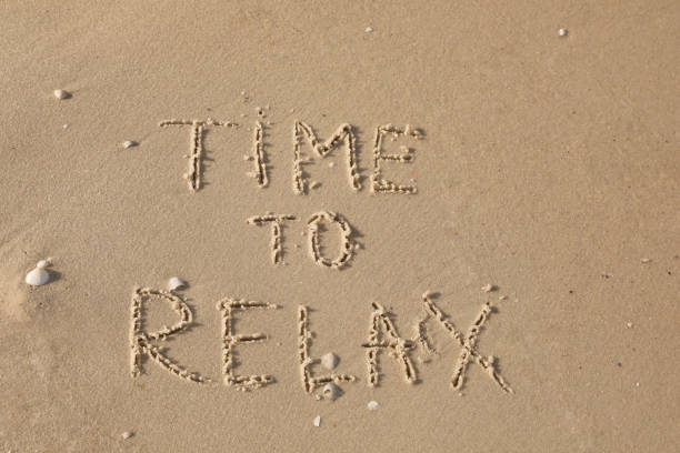 istock Phrase Time to Relax written on sand at beach, top view 1396320970