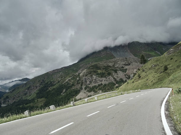 carretera asfaltada en bosque. camino a las montañas. carretera de alpen - alpes europeos fotografías e imágenes de stock