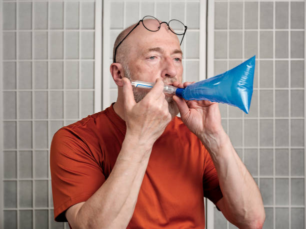 senior man performing breath test to diagnose SIBO stock photo