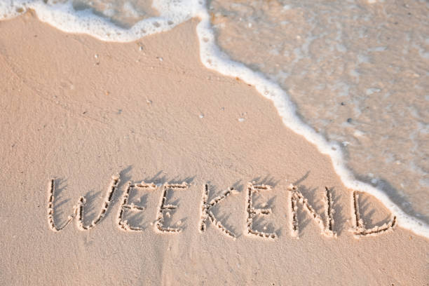 istock Word Weekend written on sand at beach, above view 1396323477
