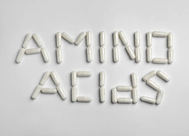 istock Phrase Amino acids made of pills on white background, flat lay 1396325205