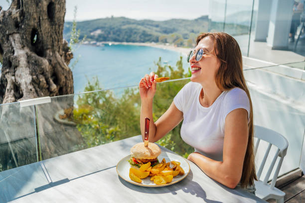 istock Woman having lunch at a restaurant with amazing view 1396325694