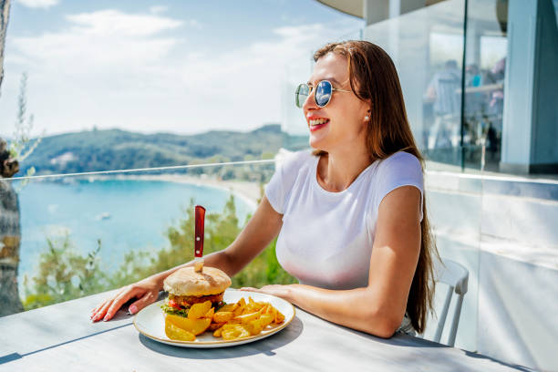 istock Woman having lunch at a restaurant with amazing view 1396326229