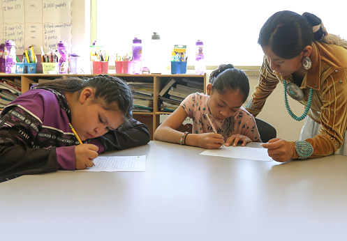 Young indigenous Navajo teacher checking her students work