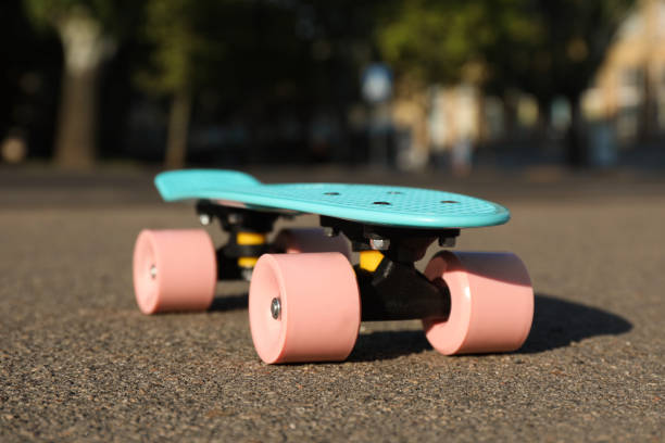 istock Light blue skateboard with pink wheels on asphalt outdoors 1396328973