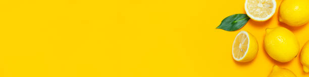 istock Ripe juicy lemons and green leaves on bright yellow background. Lemon fruit, citrus minimal concept, vitamin C. Creative summer food minimalistic background. Flat lay, top view, copy space 1396330607