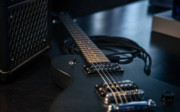 istock Close-up, black electric guitar on a dark background. 1396331913