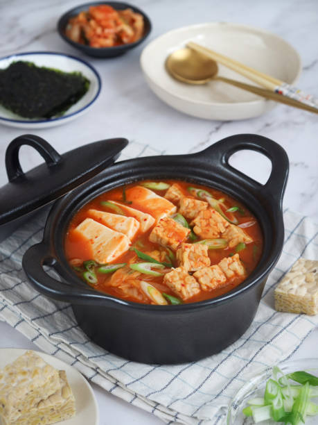 un tazón de sopa de estofado de kimchi coreano picante vegano caliente (kimchi jigae) - tempeh fotografías e imágenes de stock