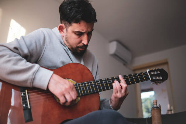 istock Focused on playing an acoustic guitar 1396335893