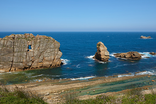 Whimsical rock formations with a turquoise blue sea and a beautiful blue sky.