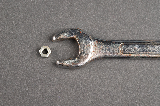 Wrench, plumbing fitting and screwdriver on metal background
