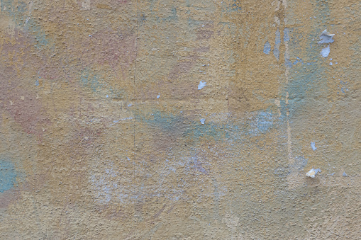 Old concrete wall with colored faded graffiti