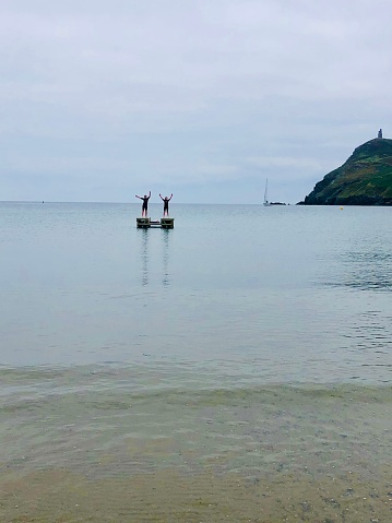 Girls standing on a platform in the sea