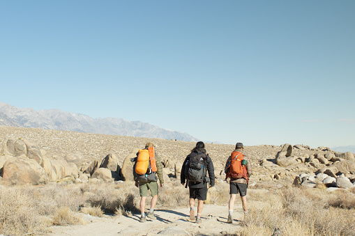Friends hiking while on a camping trip in California's Alabama Hills