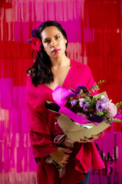 istock Young woman posing with pink flowers 1396351576