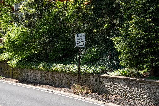 A warning sign for the height of a bridge along with a no parking warning.  This is a suburban road in Wellesley, MA, just outside of Boston.