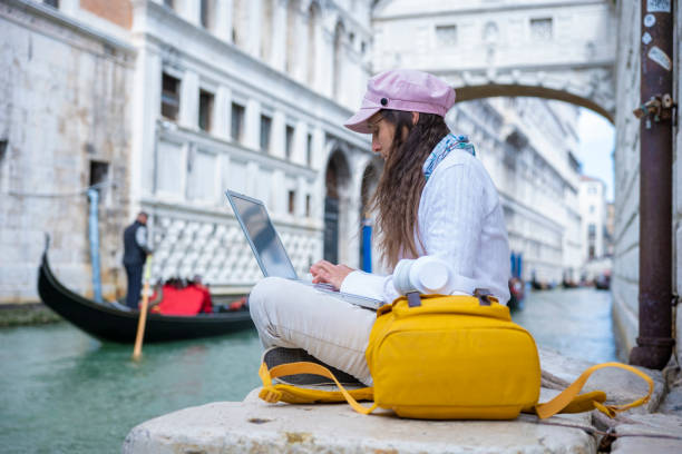 istock Woman works on laptop while on vacation in Venice. 1396362157