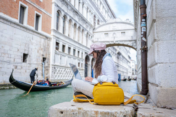 istock Woman works on laptop while on vacation in Venice. 1396362159