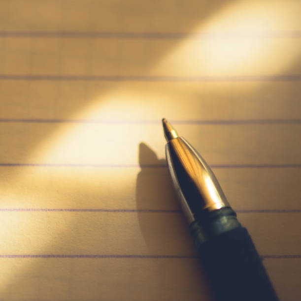 monochromatic close-up image of a classic ballpoint pen resting on a blank ruled notebook. the mood is serious, reflective, and focused. concept of writing, studying, planning, journalism, or creativity. ideal for blogs, educational materials, business reports, and storytelling.