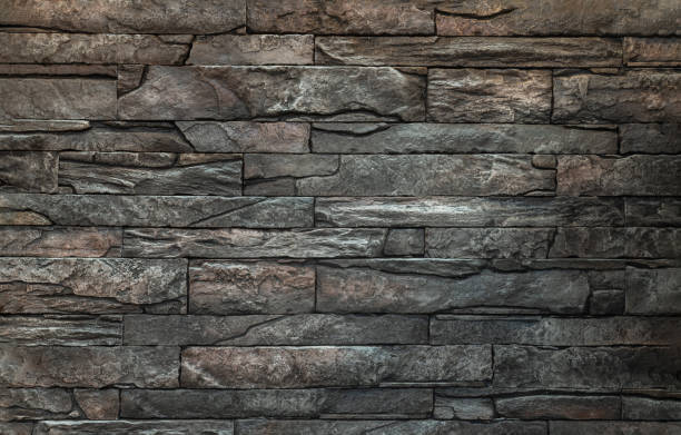Soft light on pieces of Stone cladding wall. made of striped stacked slabs of natural brown rocks. Soft light on pieces of Stone cladding wall. made of striped stacked slabs of natural brown rocks for walls texture and background, Copy space, Selective focus. crag stock pictures, royalty-free photos & images