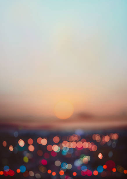 Evening view of abstract bokeh lights is blurred with the dramatic sky and clouds at dusk.