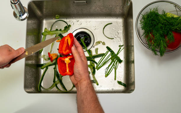 istock man cutting sweet pepper with a knife over the sink 1396367222